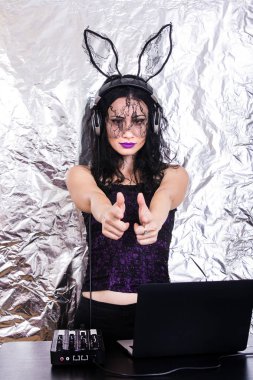 Esmer Dj dantel maskesi ve mor korse, Cadılar Bayramı kutluyor. Oyun ve müzik karıştırma kadın Dj. Cadılar Bayramı kavramı.