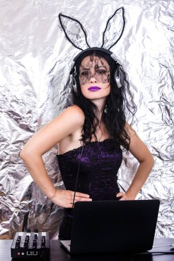 Esmer Dj dantel maskesi ve mor korse, Cadılar Bayramı kutluyor. Oyun ve müzik karıştırma kadın Dj. Cadılar Bayramı kavramı.