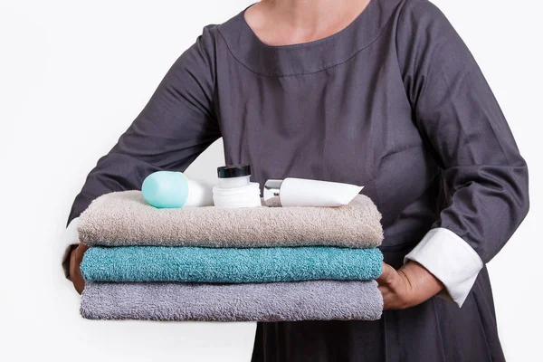メイドの手は タオルおよび浴室の付属品を保持します 女性スタッフ — ストック写真