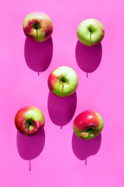 Olgun sarı ve kırmızı elma Lila veya pembe arka plan üzerinde ışık ve gölge kavramı.