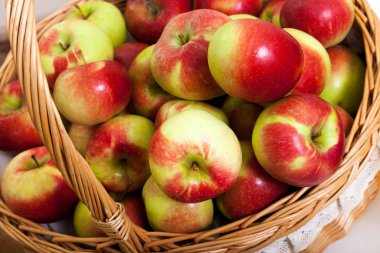 Beyaz zemin üzerinde bir sepet içinde kırmızı ve Sarı elmalar. Sulu meyve Close-up.