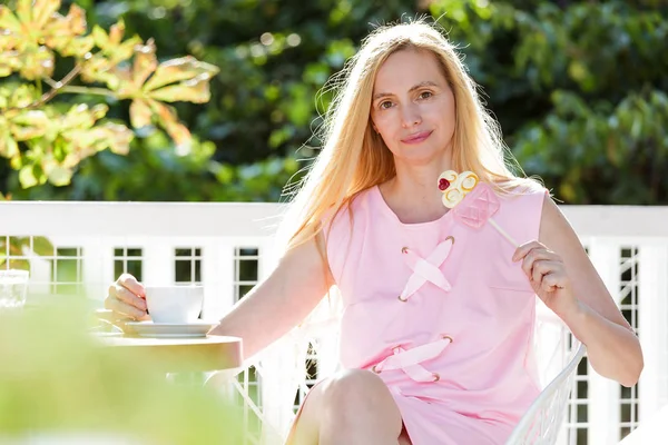 Сексуальная Женщина Средних Лет Одетая Розовое Платье Сидит Фоне Листьев — стоковое фото