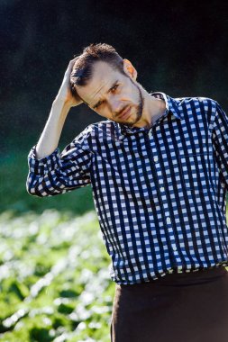 Yağmur altında güçlü, sırılsıklam bir adam portresi. Yaz aylarında yağmur altında ıslak genç adam.