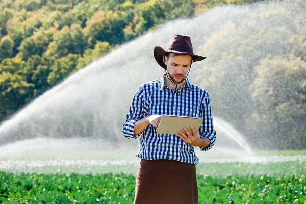 농부는 스프링 시스템 배경에 디지털 태블릿 컴퓨터를 농장에 작물의 — 스톡 사진