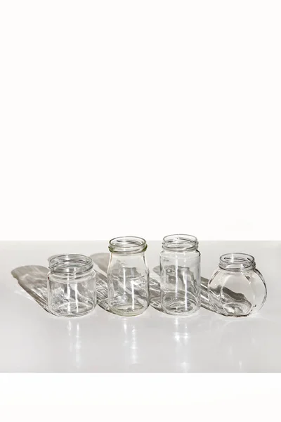 Cuatro Frascos Vidrio Limpios Sobre Mesa Blanca Con Sombra Conjunto — Foto de Stock