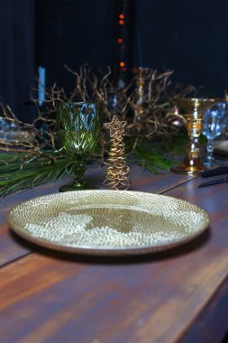 Yeni yıl tatili tablo altın plaka ile dekore edilmiştir. Noel ağacı ile vintage mavi tabloda Vintage şarap bardakları.