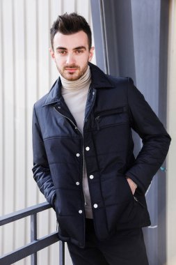 Moda adam. Yakışıklı ciddi erkek model portre aşınma mavi ceket, gri arka plan üzerinde genç adam.