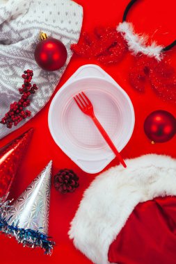 Beyaz plastik tabak ve kırmızı çatal kırmızı zemin üzerine kırmızı Noel dekorasyonu. Hayırsever yardım etmek için yoksul ve evsiz yeni yıl tarih kavramı.