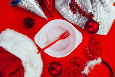 Beyaz plastik tabak ve kırmızı çatal kırmızı zemin üzerine kırmızı Noel dekorasyonu. Hayırsever yardım etmek için yoksul ve evsiz yeni yıl tarih kavramı.