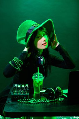 Yeşil arka plan Dj genç İrlandalı kız portresi. DJ kadın headphne ve yeşil hat ile müzik St. Patrick parti üzerinde çalış..