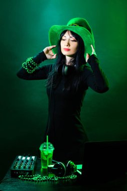 Yeşil arka plan Dj genç İrlandalı kız portresi. DJ kadın headphne ve yeşil hat ile müzik St. Patrick parti üzerinde çalış..