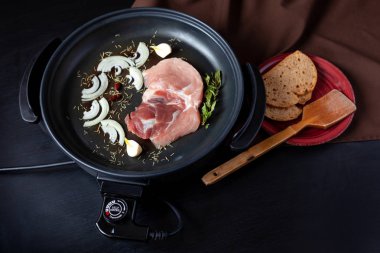 Elektrikli tava etli tablo. Herhangi bir yerde yemek pişirmek için bağımsız yardımcı tava.
