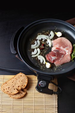 Elektrikli tava etli tablo. Herhangi bir yerde yemek pişirmek için bağımsız yardımcı tava.