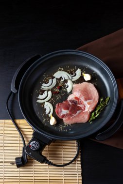 Elektrikli tava etli tablo. Herhangi bir yerde yemek pişirmek için bağımsız yardımcı tava.