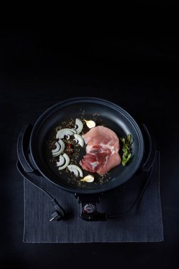 Elektrikli tava etli tablo. Herhangi bir yerde yemek pişirmek için bağımsız yardımcı tava.