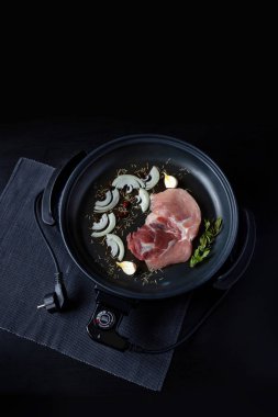 Elektrikli tava etli tablo. Herhangi bir yerde yemek pişirmek için bağımsız yardımcı tava.