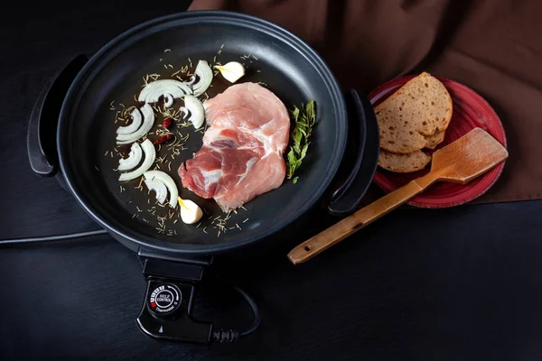 Elektrikli tava etli tablo. Herhangi bir yerde yemek pişirmek için bağımsız yardımcı tava.