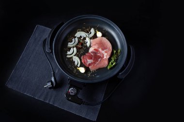 Elektrikli tava etli tablo. Herhangi bir yerde yemek pişirmek için bağımsız yardımcı tava.