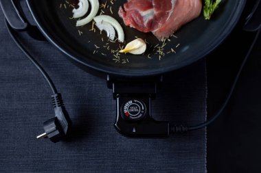 Elektrikli tava etli tablo. Herhangi bir yerde yemek pişirmek için bağımsız yardımcı tava.