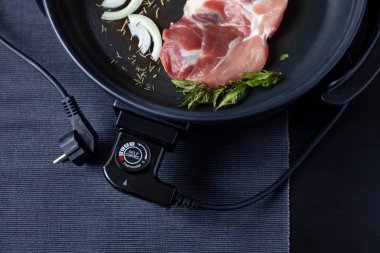 Elektrikli tava etli tablo. Herhangi bir yerde yemek pişirmek için bağımsız yardımcı tava.