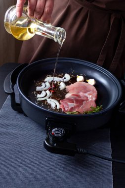 Elektrikli tava etli tablo. Herhangi bir yerde yemek pişirmek için bağımsız yardımcı tava.