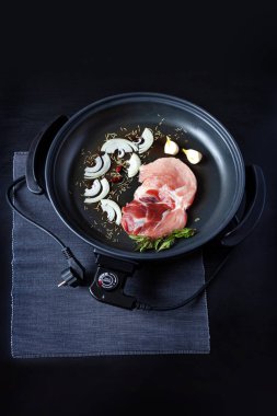 Elektrikli tava etli tablo. Herhangi bir yerde yemek pişirmek için bağımsız yardımcı tava.