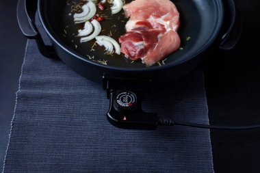 Elektrikli tava etli tablo. Herhangi bir yerde yemek pişirmek için bağımsız yardımcı tava.