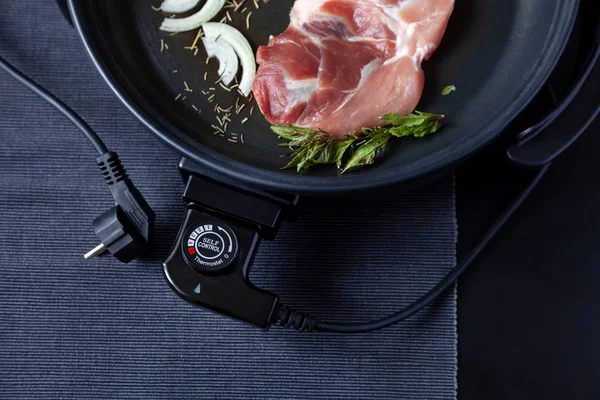 Elektrikli tava etli tablo. Herhangi bir yerde yemek pişirmek için bağımsız yardımcı tava.