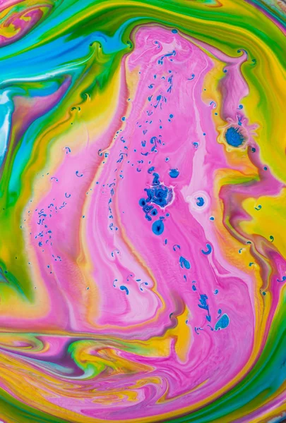 Abstract colored pink, yellow and green acrylic paints. View of macro world through the microscope.