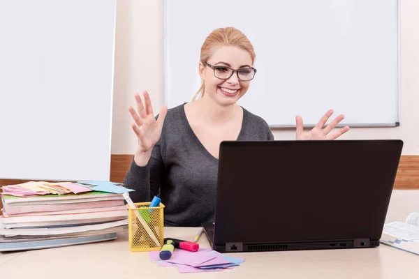 コンピューターに白い Mackground に金髪の若い女性の肖像画 オフィスで女性が教えるオンライン — ストック写真