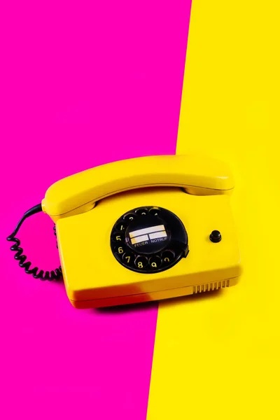 Ретро винтажный телефон телефон телефон желтый розовый красный фиолетовый пластик оранжевый диско фон старый стиль тени 90 — стоковое фото