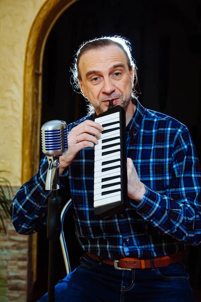 singer man old school fashioned microphone hairstyle karaoke portrait face blue eyes long hair retro vintage tool accordion piano