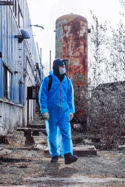 Человек окружающей среды маска для лица пак маскировки маска для лица защитная общая синяя оранжевая растительность завод заброшенный катастрофа — стоковое фото