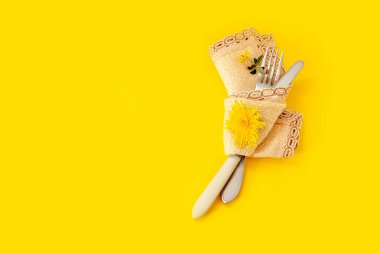 Sarı arka plan çatal bıçak çiçek karahindiba yeşil buket peçete havlusu