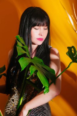 monstera kız güneş ışık gölge tropikal sarı turuncu genç kadın glamour arka plan