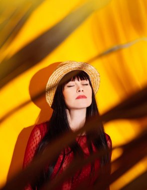 kız şapka güneş ışık gölge tropikal sarı turuncu genç kadın arka plan kırmızı elbise