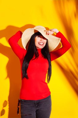 kız hasır şapka güneş gözlüğü ışık gölge tropikal sarı turuncu genç kadın arka plan kırmızı t-shirt