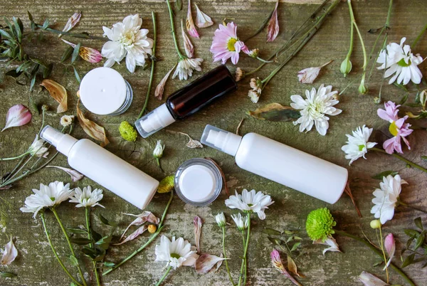 Recipiente cosmético frasco spray dispensador flores verdes branco velho fundo de madeira país lado — Fotografia de Stock