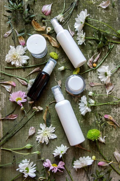 Cosmetische container jar spray dispenser groene bloemen witte oude houten achtergrond landkant — Stockfoto