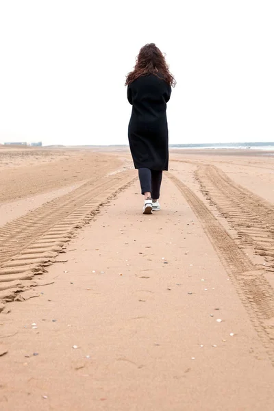 girl sand sea woman wind rain way road walk stap North Scheveningen The Hague Netherlands