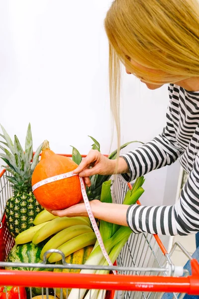 Vrouw fruit supermarkt fitness 50 plus groenten maat mand pompoen winkelen trolly rode artikel aankoop straatmarkt — Stockfoto