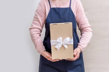 Üniformalı Dağıtım Hizmetleri Kadın İşçisi, Beyaz ve Zanaat Arkaplanı Müşteri için kağıt kutu tutuyor..