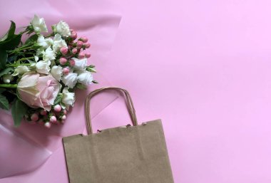Pembe çiçekler ve el işi kağıtlar pembe arka planda. Müşteri Paketleme Hizmeti Konsepti.