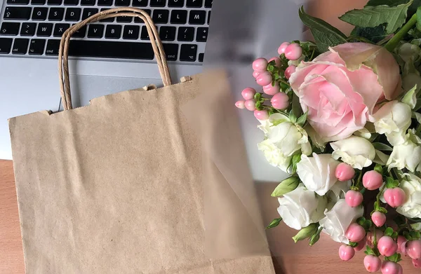 Dizüstü bilgisayardaki Pembe Çiçekler ve Kağıtlar. Müşteri Paketleme Hizmeti Konsepti.