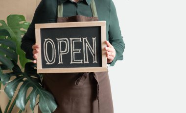 Kadın Elleri Metni Açık Gösterge Paneli Tutuyor. Önlüklü İşçi Kafe ya da Market Açılışını Gösteriyor.