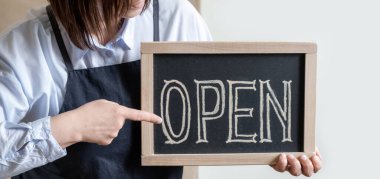 Kadın Elleri Metni Açık Gösterge Paneli Tutuyor. Önlüklü İşçi Kafe ya da Market Açılışını Gösteriyor.