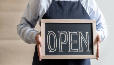 Kadın Elleri Metni Açık Gösterge Paneli Tutuyor. Önlüklü İşçi Kafe ya da Market Açılışını Gösteriyor.