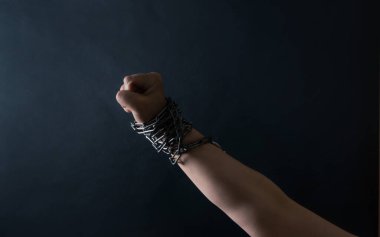 El Yumruğu, siyah arka planda zincirlenmiştir. Savaş ve Özgürlük kavramı..