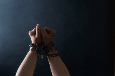Ellerin Yumrukları Zincirlenmiş Siyah arka planda, Savaş ve Özgürlük kavramı.