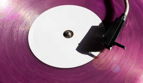 Vintage record player with pink vinyl record on the black background. Old school style.